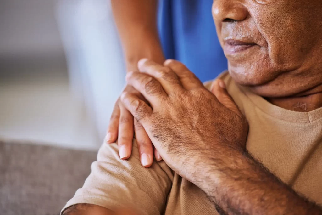 hospice nurse holding a hospice patient's shoulder compassionately